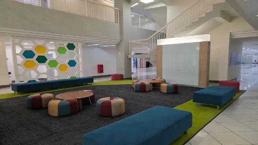 Colourful breakout lounge area with ottomans, benches and honeycomb wall feature