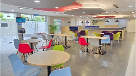 Bright and colourful cafe dining area with round tables and multicoloured chairs