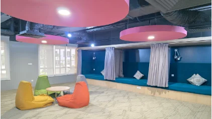 Relaxation nap room with bean bags, bench seating and pink ceiling lights
